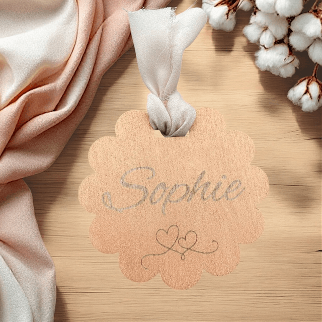 Marque-place en bois peint en forme de fleur avec son ruban