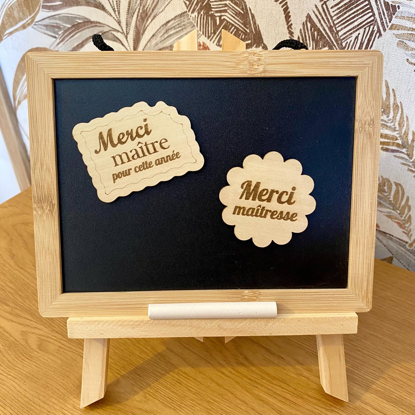 Plusieurs magnets en bois fixés sur la porte d'un réfrigérateur au milieu de photos de famille."