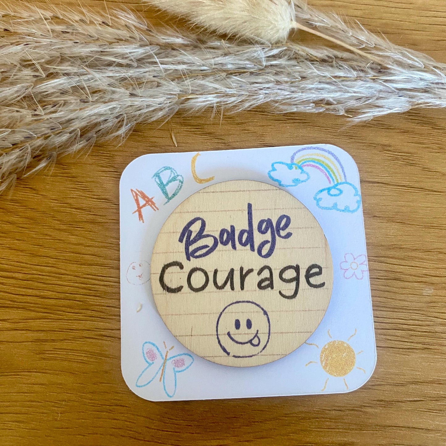 Badge rond en bois motif smiley bleu pour cartable