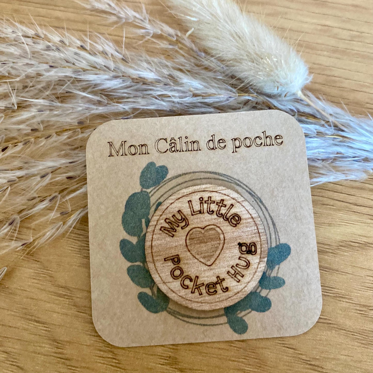 Gros plan sur la précision de la gravure laser sur le bois naturel du câlin de poche "My little pocket hug"