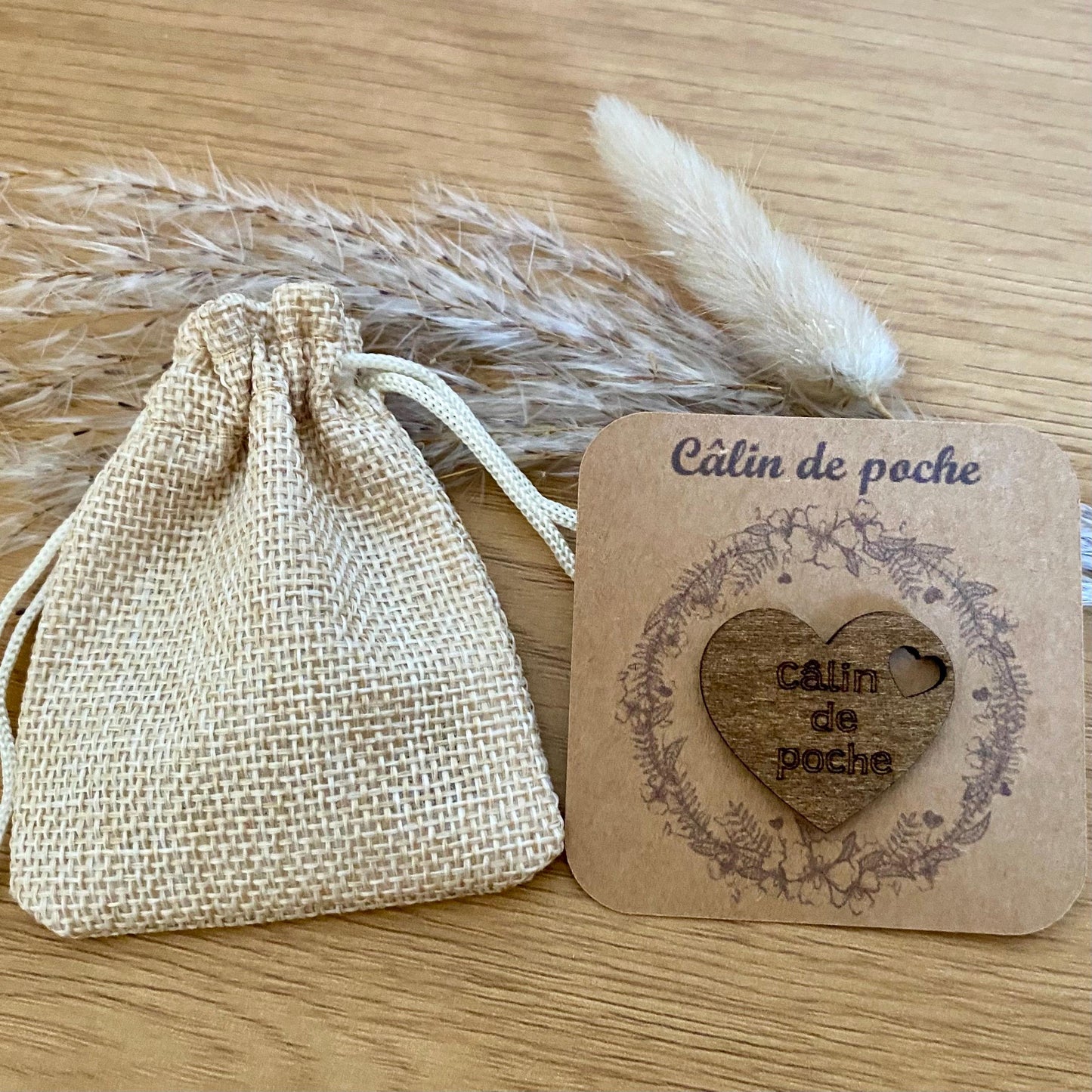 coeur en bois gravé sur son support kraft et accompagné de son petit pochon