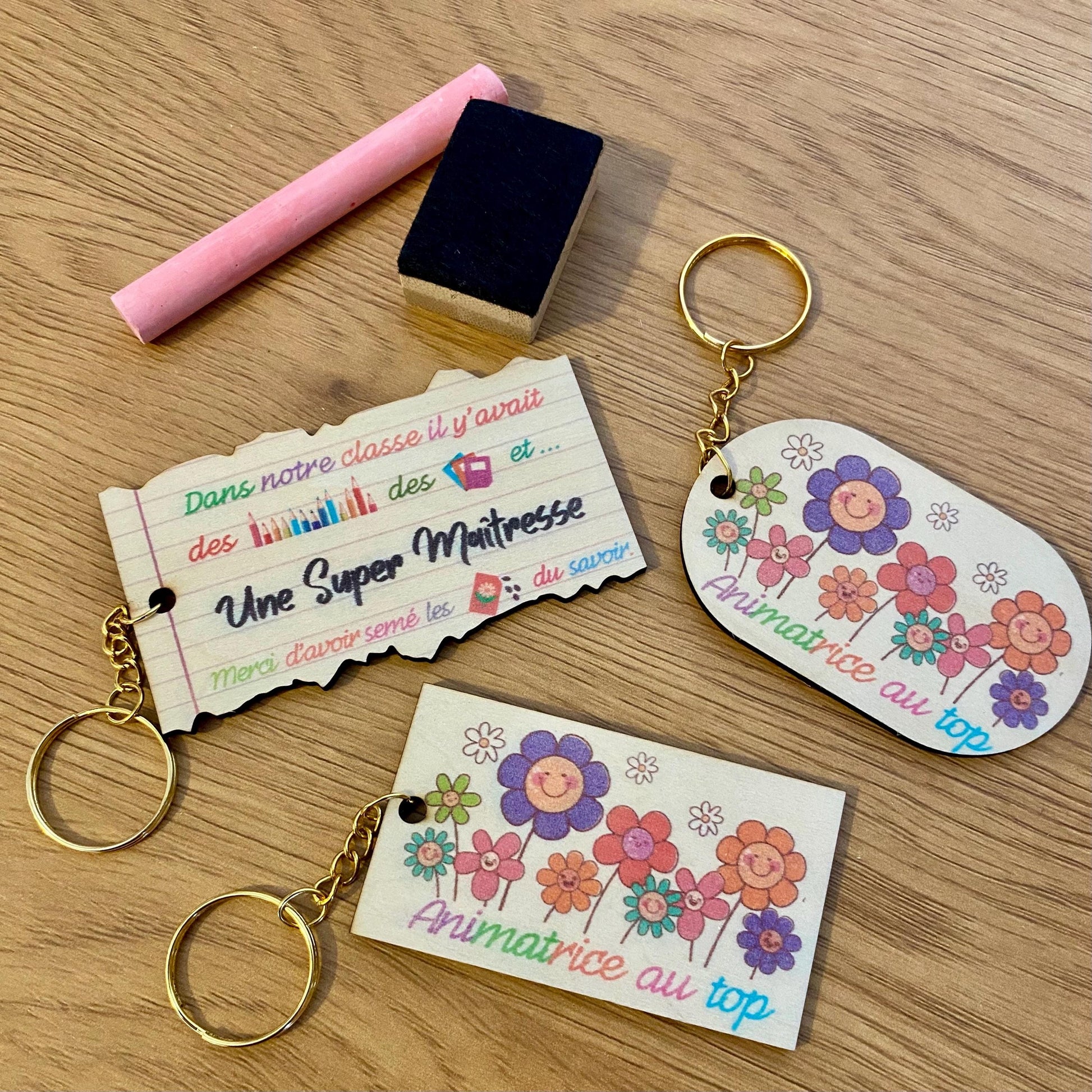 Magnet en bois et porte-clés assorti avec dessin floral d'enfant, présentés dans un emballage cadeau en papier de soie beige et raphia."