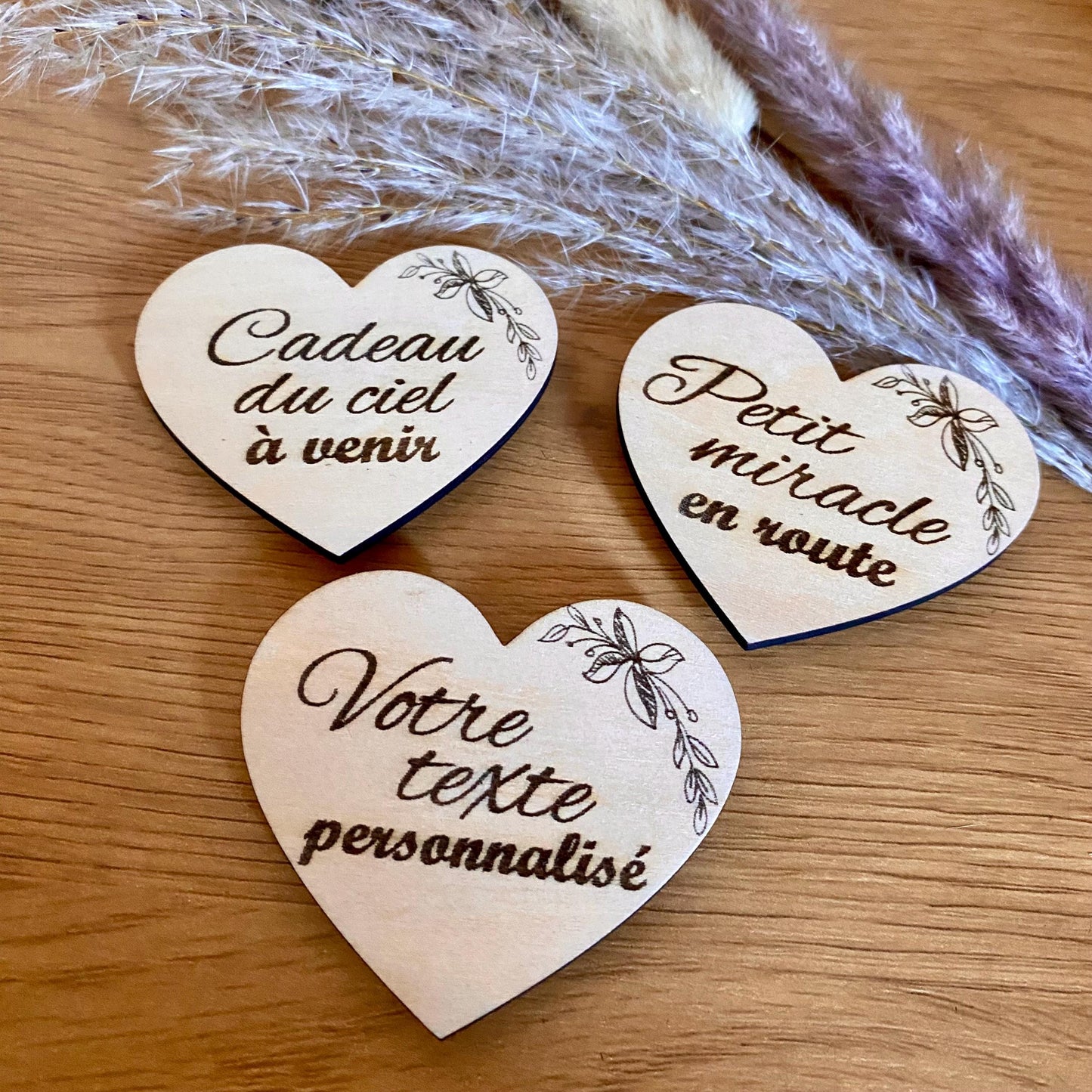 Un magnet en bois "Annonce Grossesse" mis en avant sur un support magnétique, avec une belle mise au point sur la gravure.