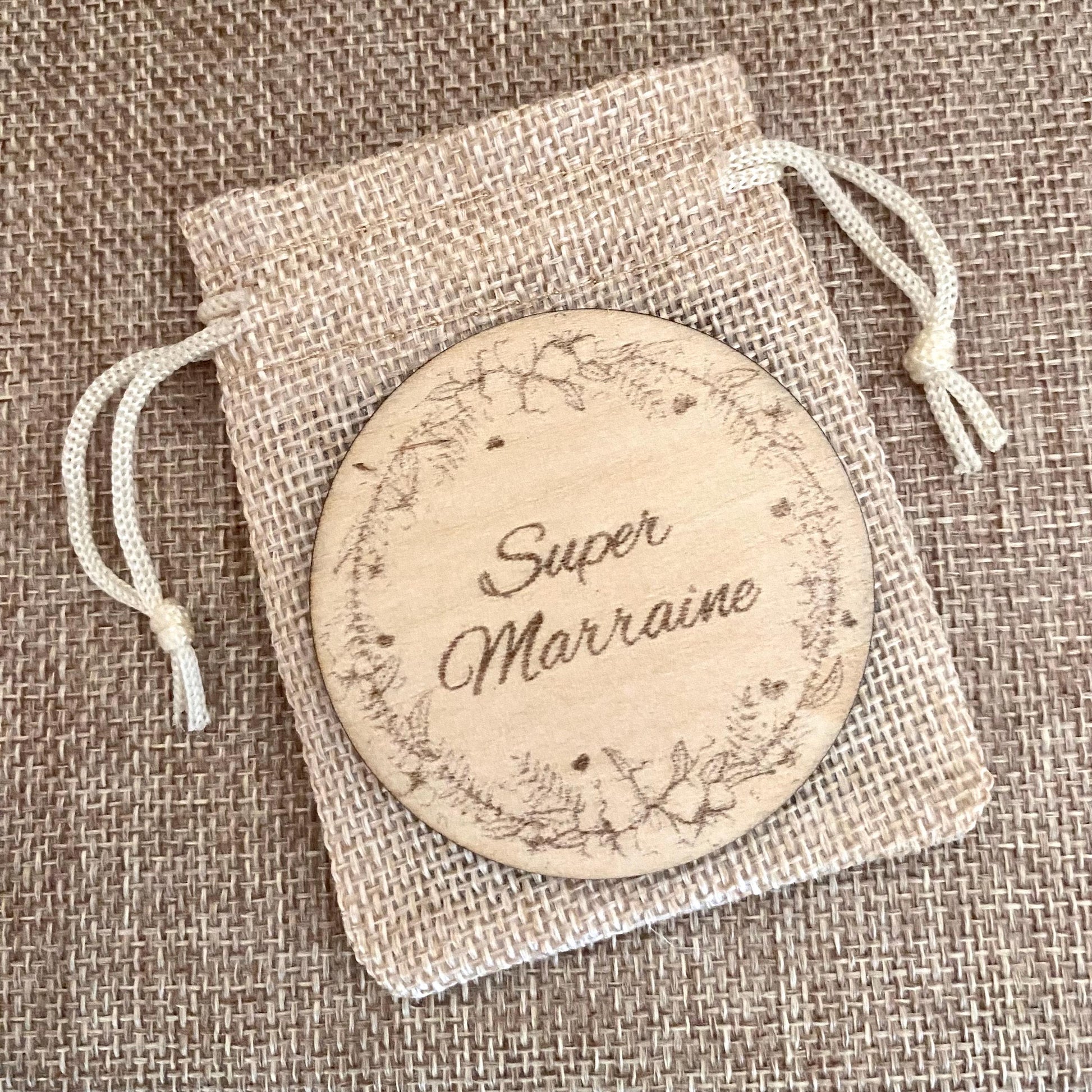 magnet en bois gravé pour annonce grossesse sur son pochon gravure super marraine