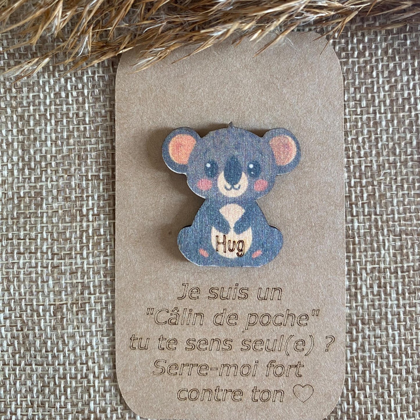 Gros plan sur la gravure fine du koala en bois, mettant en avant la précision du travail artisanal.