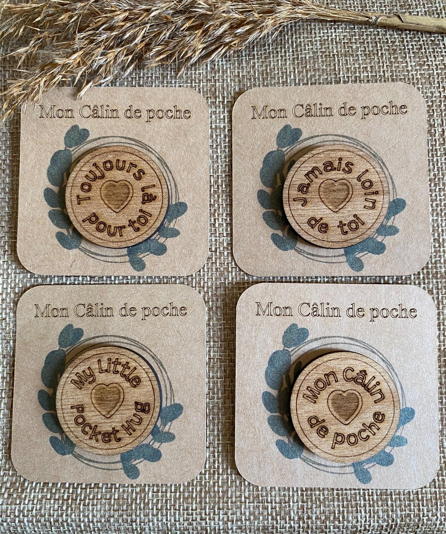 Plusieurs Câlins de Poche en bois avec leurs messages gravés, disposés de manière esthétique.