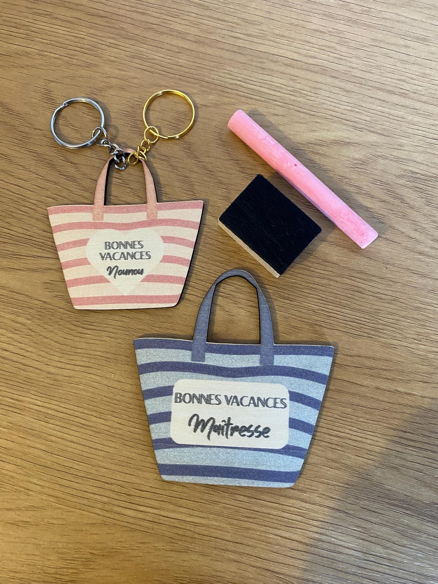 Porte-clés en bois assorti au magnet, posé sur un support en bois, évoquant une ambiance de vacances."