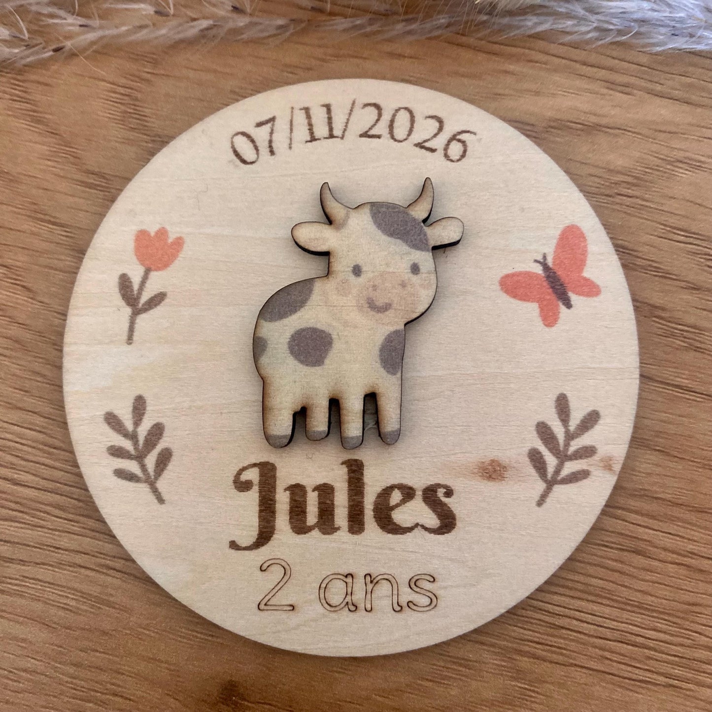 magnet en bois thème ferme posé sur une table d'anniversaire décorée.
