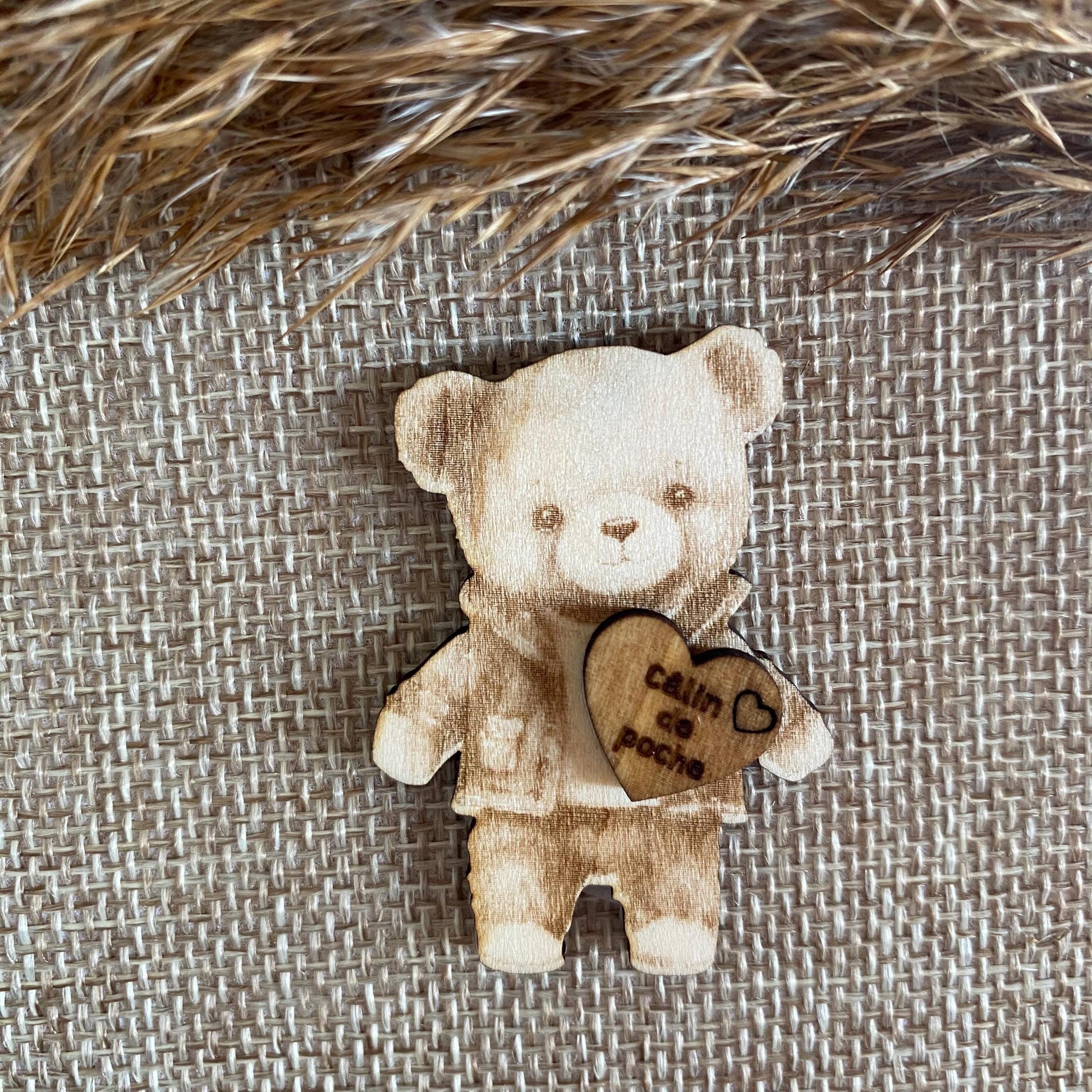 Gros plan sur la gravure du visage de l'ours et la qualité de la finition du bois.
