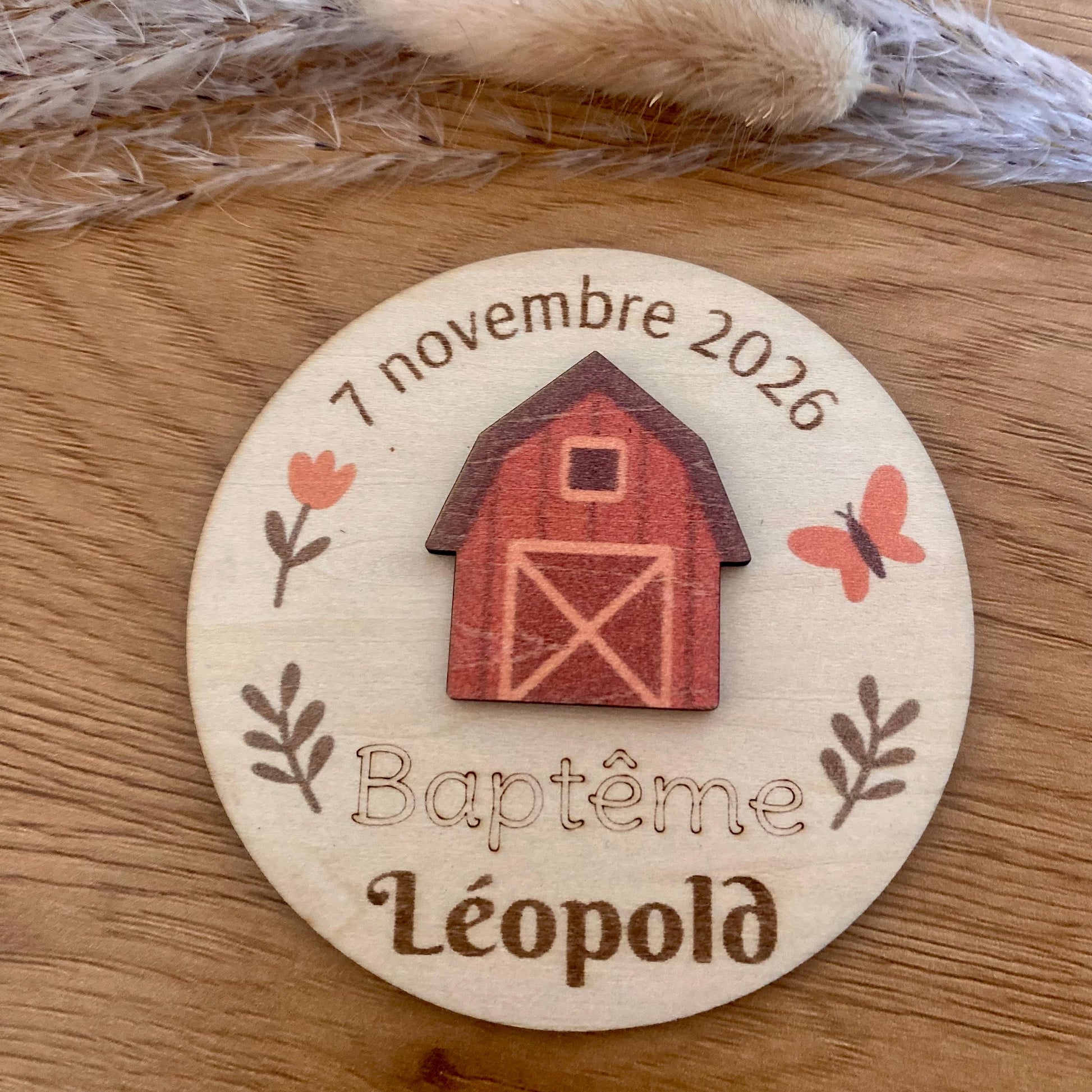 Magnet thème ferme disposé sur une table de baptême champêtre.