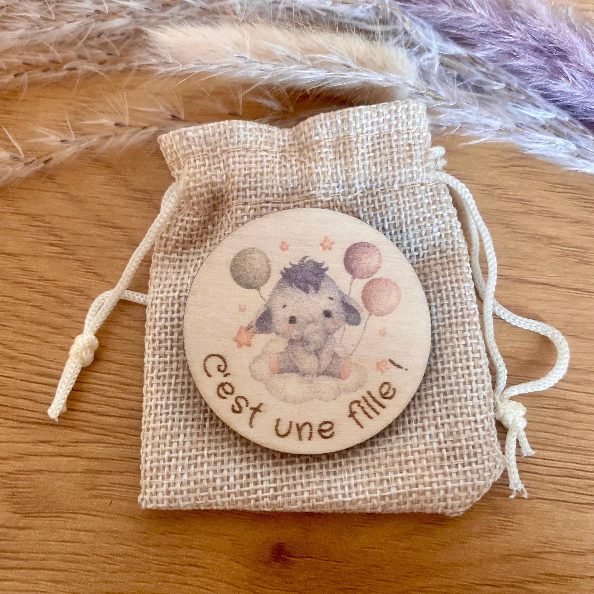 Magnet personnalisé présenté dans son petit pochon en tissu, prêt à offrir.

