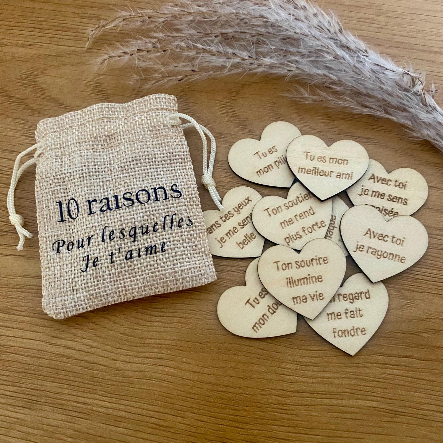 Un mini pochon en tissu laissant apparaître des petits cœurs en bois gravés.