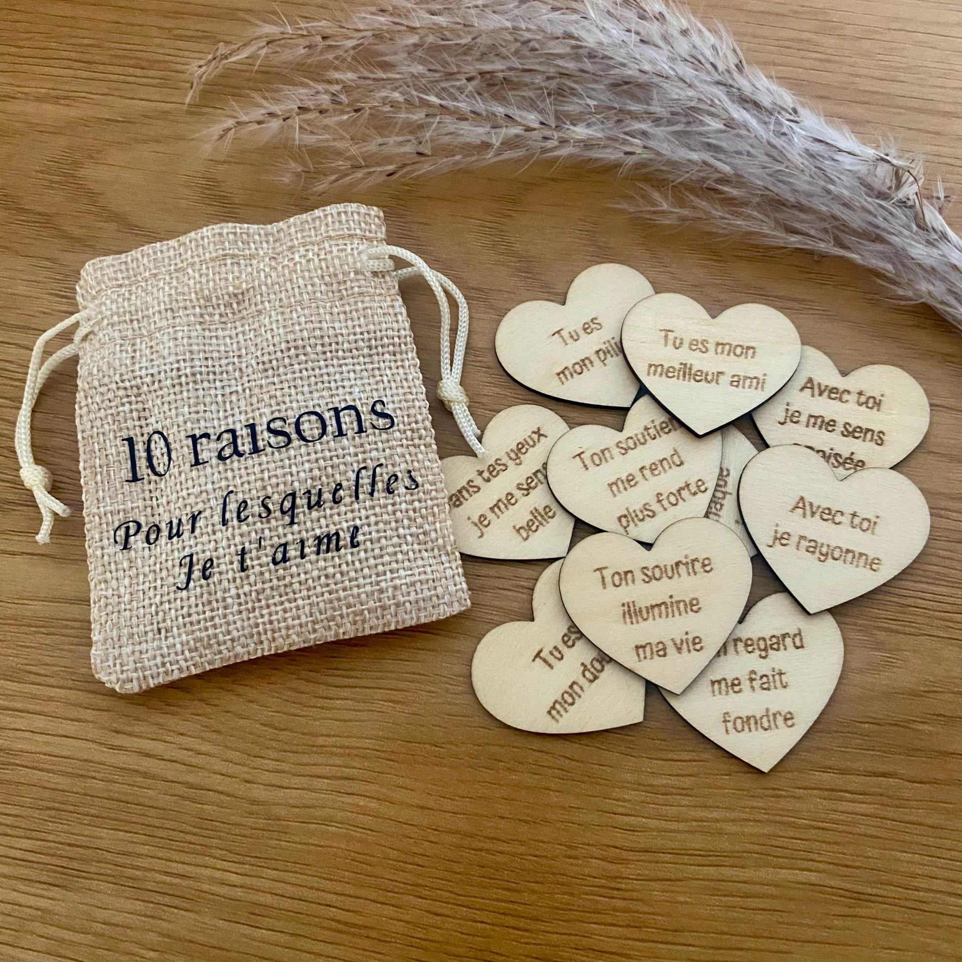 Un mini pochon en tissu laissant apparaître des petits cœurs en bois gravés.