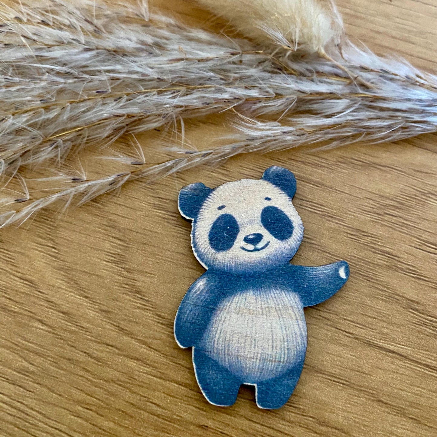 Le câlin de poche panda tenu dans une main, illustrant son format idéal à glisser dans une poche.