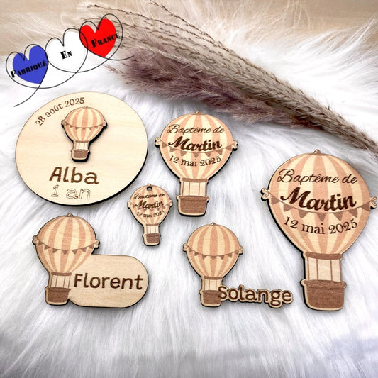Mise en scène aérienne de la collection "Montgolfière" avec des magnets et marque-places et étiquettes disposés avec légèreté.