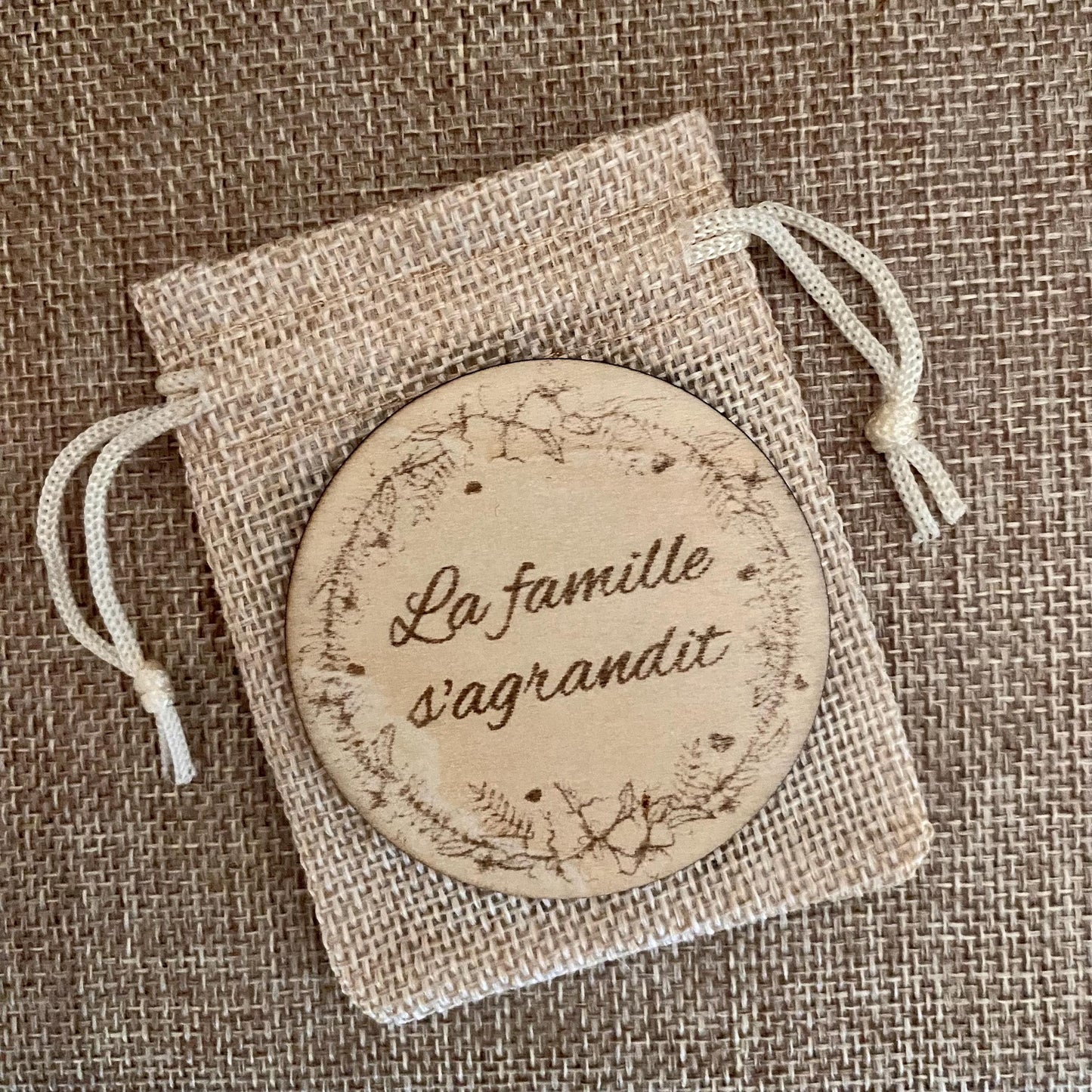 magnet en bois gravé pour annonce grossesse sur son pochon gravure la famille s agrandit