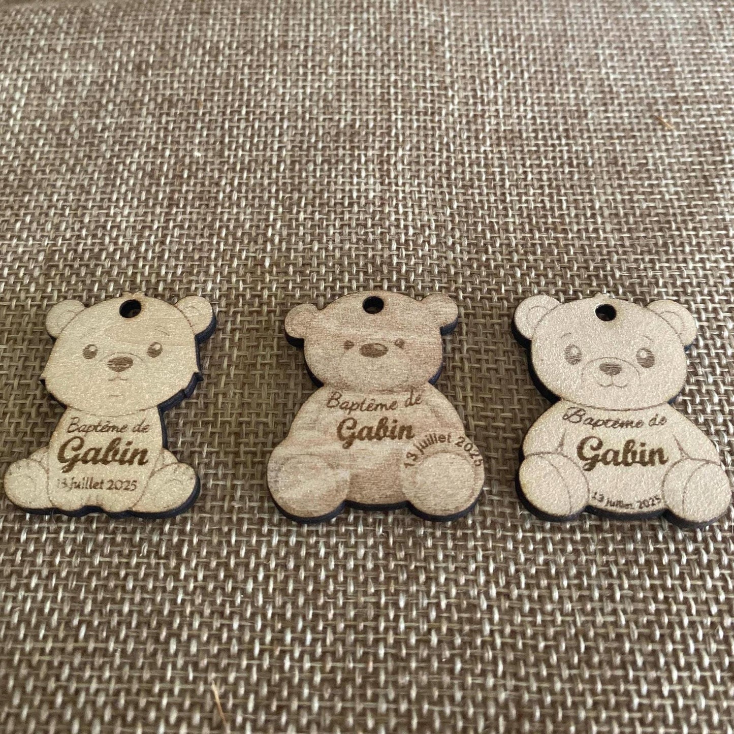 Différents modèles d'étiquettes ourson en bois disposés côte à côte pour illustrer les options de personnalisation.