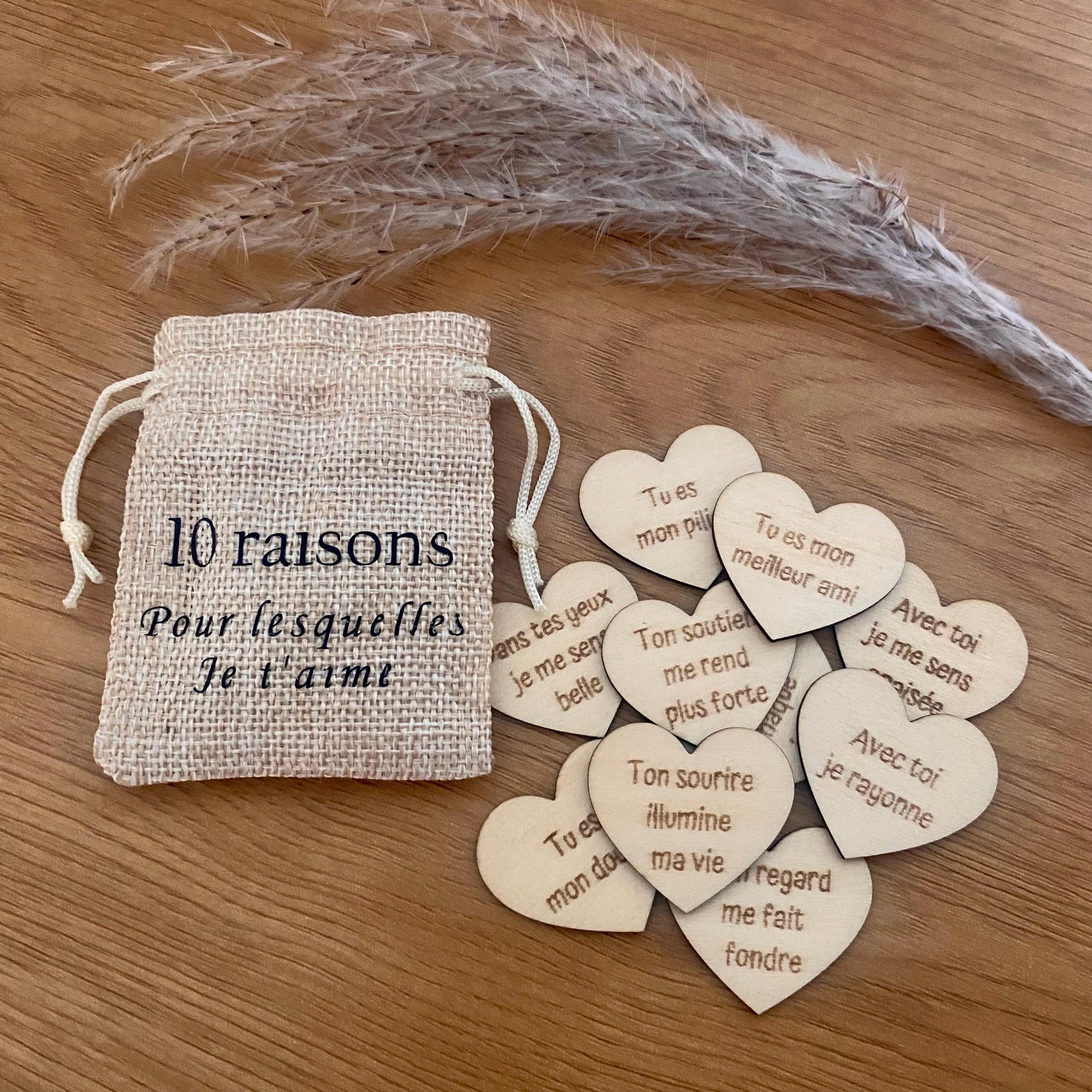 Un mini pochon en tissu laissant apparaître des petits cœurs en bois gravés.