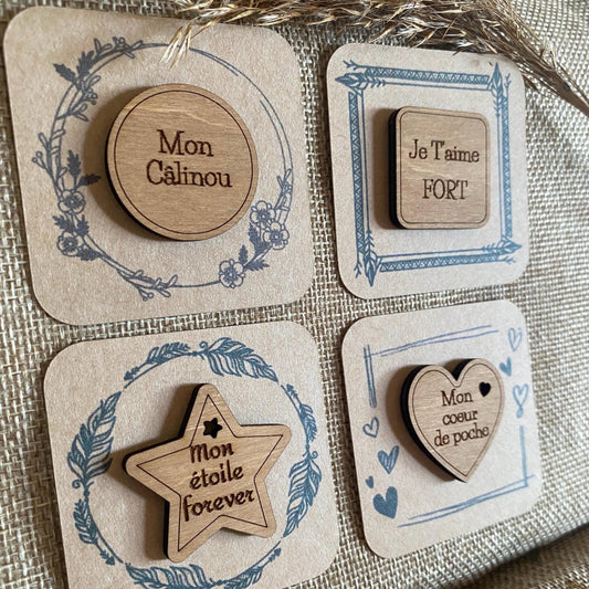 Un assortiment de Câlins de Poche en bois avec différentes formes et messages gravés.