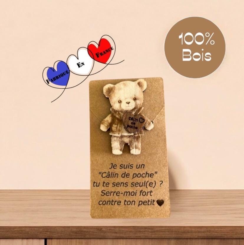 Un adorable Câlin de Poche Ours en bois posé sur un support kraft