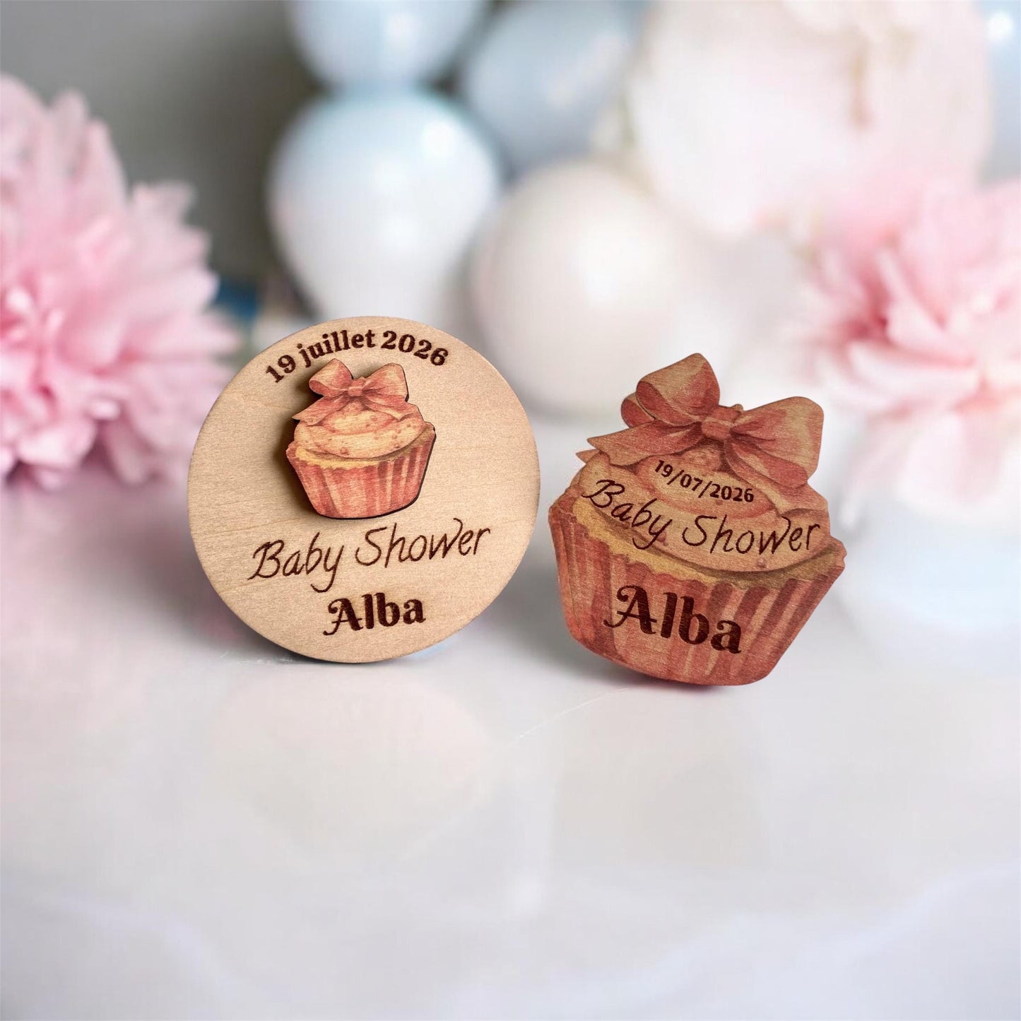 Magnets cupcake disposés sur une table de fête aux côtés de gourmandises réelles.
