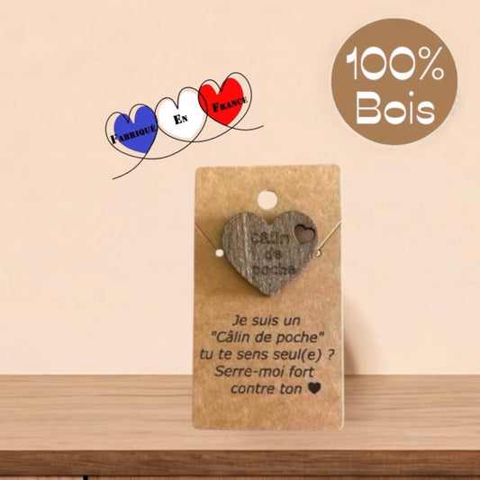 Un Câlin de Poche Cœur en bois, mis en valeur sur une surface naturelle, avec une lumière douce.