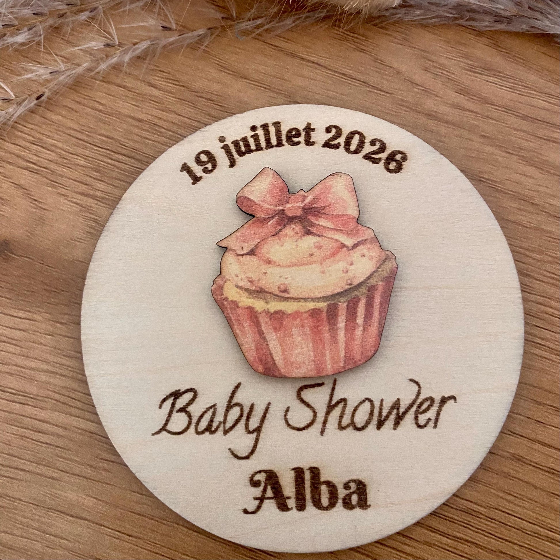 Gros plan sur la superposition du cupcake en relief sur le magnet rond et la précision de la gravure laser.