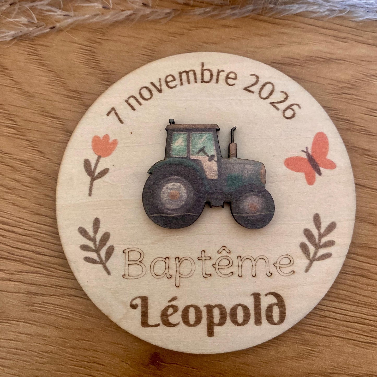 Magnet thème tracteur disposé sur une table de baptême champêtre.