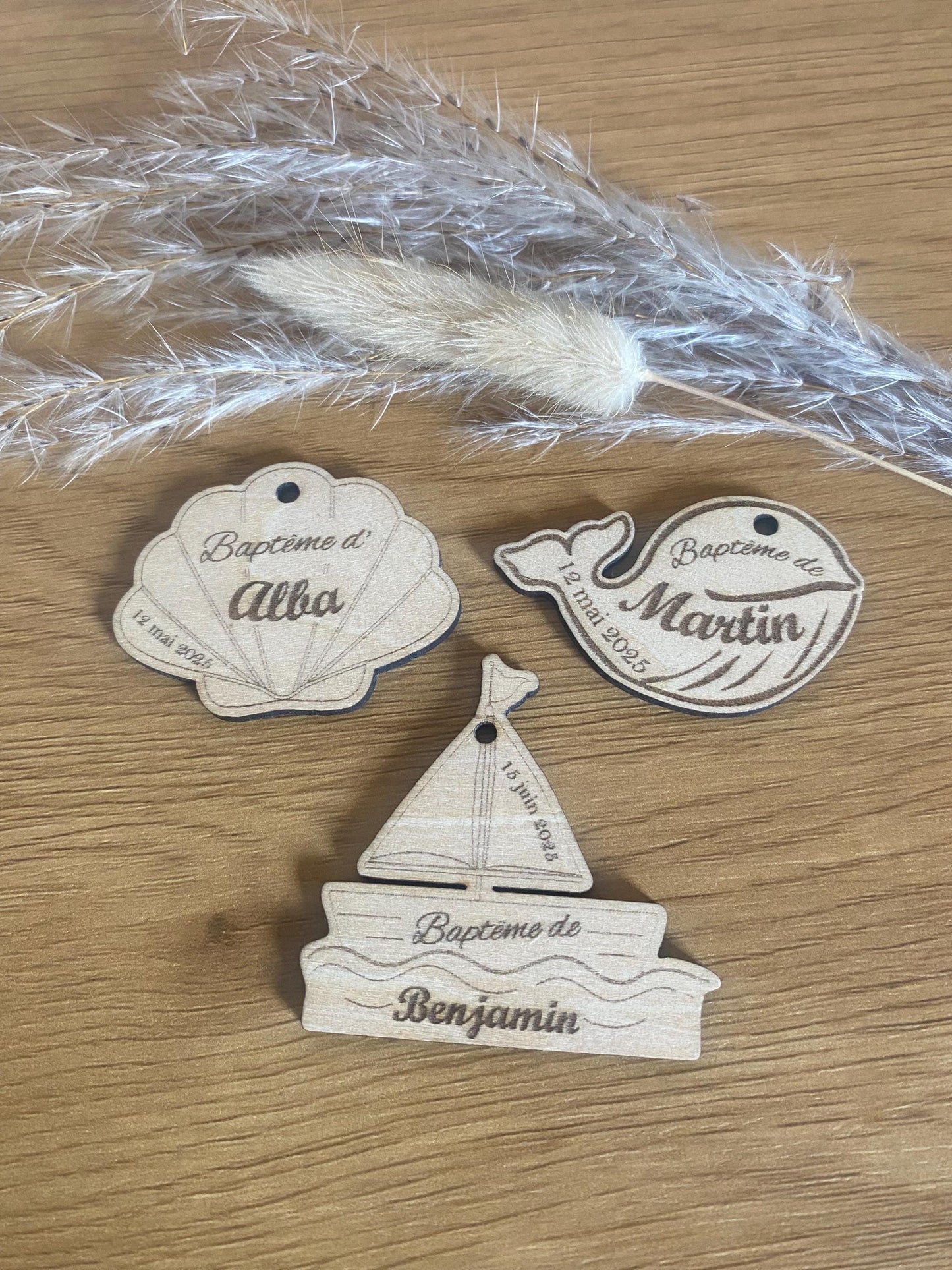 Sélection d'étiquettes en bois aux formes variées coquillage, baleine, bateau) posées sur un support neutre."