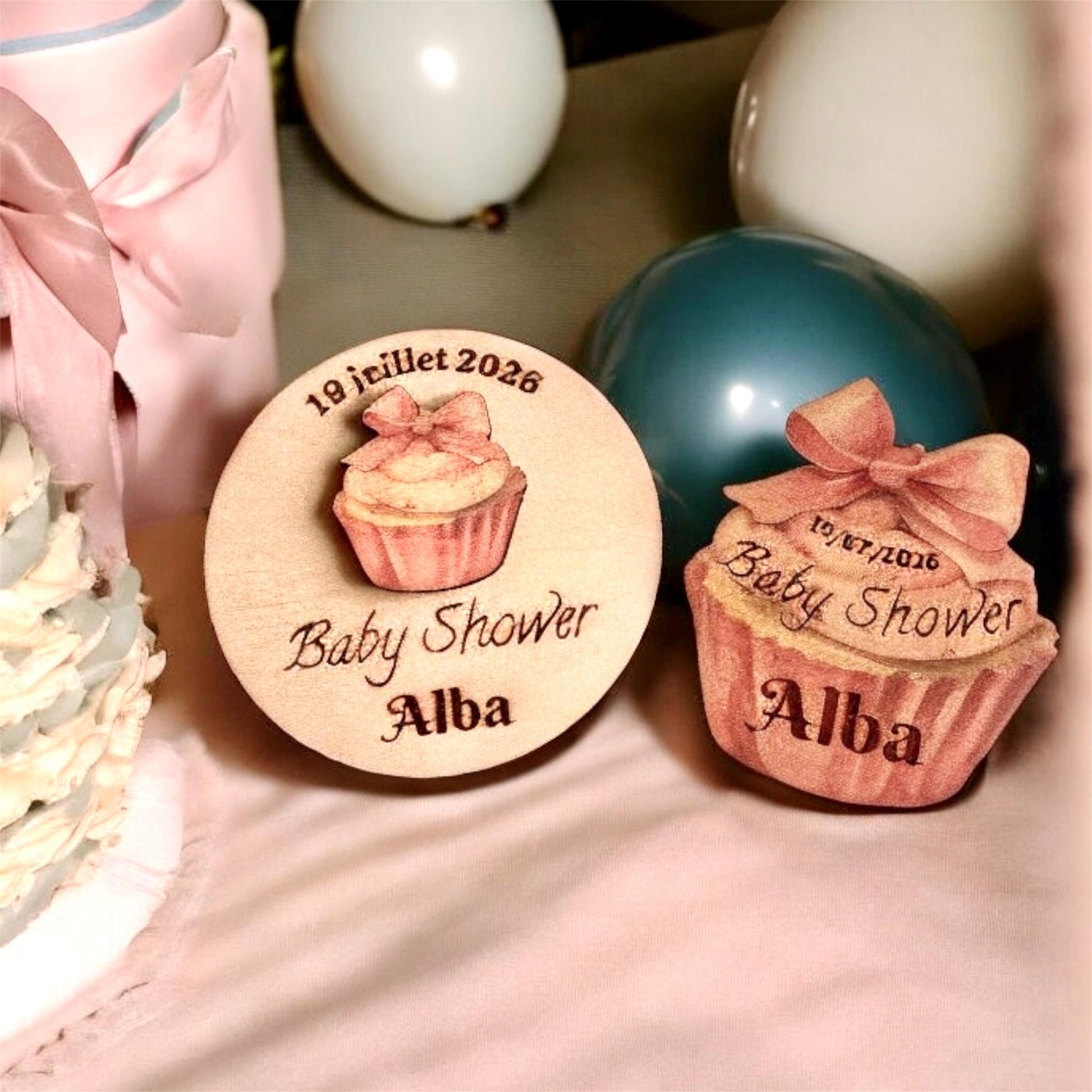 Magnets cupcake disposés sur une table de fête aux côtés de gourmandises réelles.