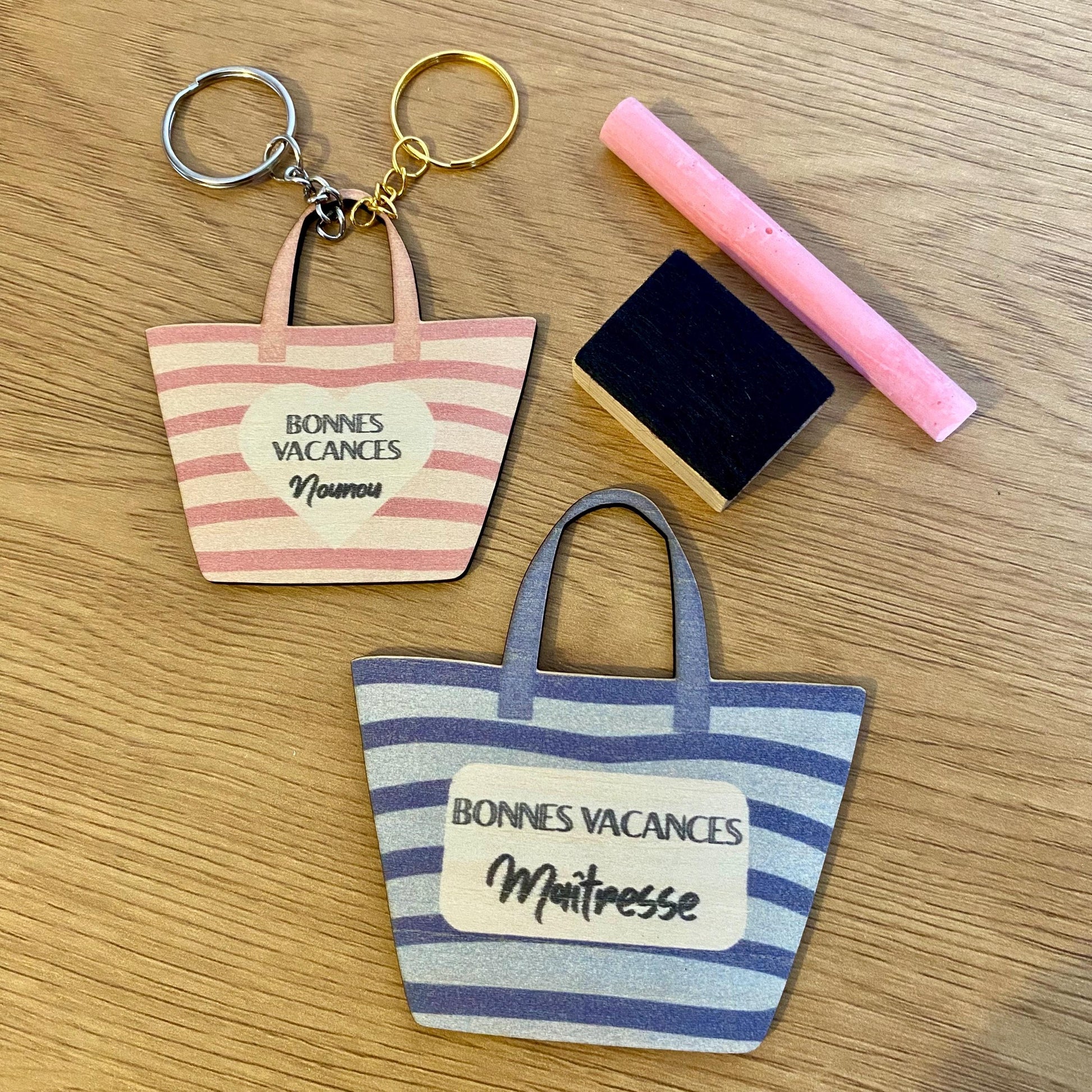 Porte-clés en bois assorti au magnet, posé sur un support en bois, évoquant une ambiance de vacances."