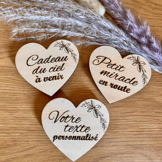 Un magnet en bois "Annonce Grossesse" en forme de coeur  et motif floral avec texte à personnaliser