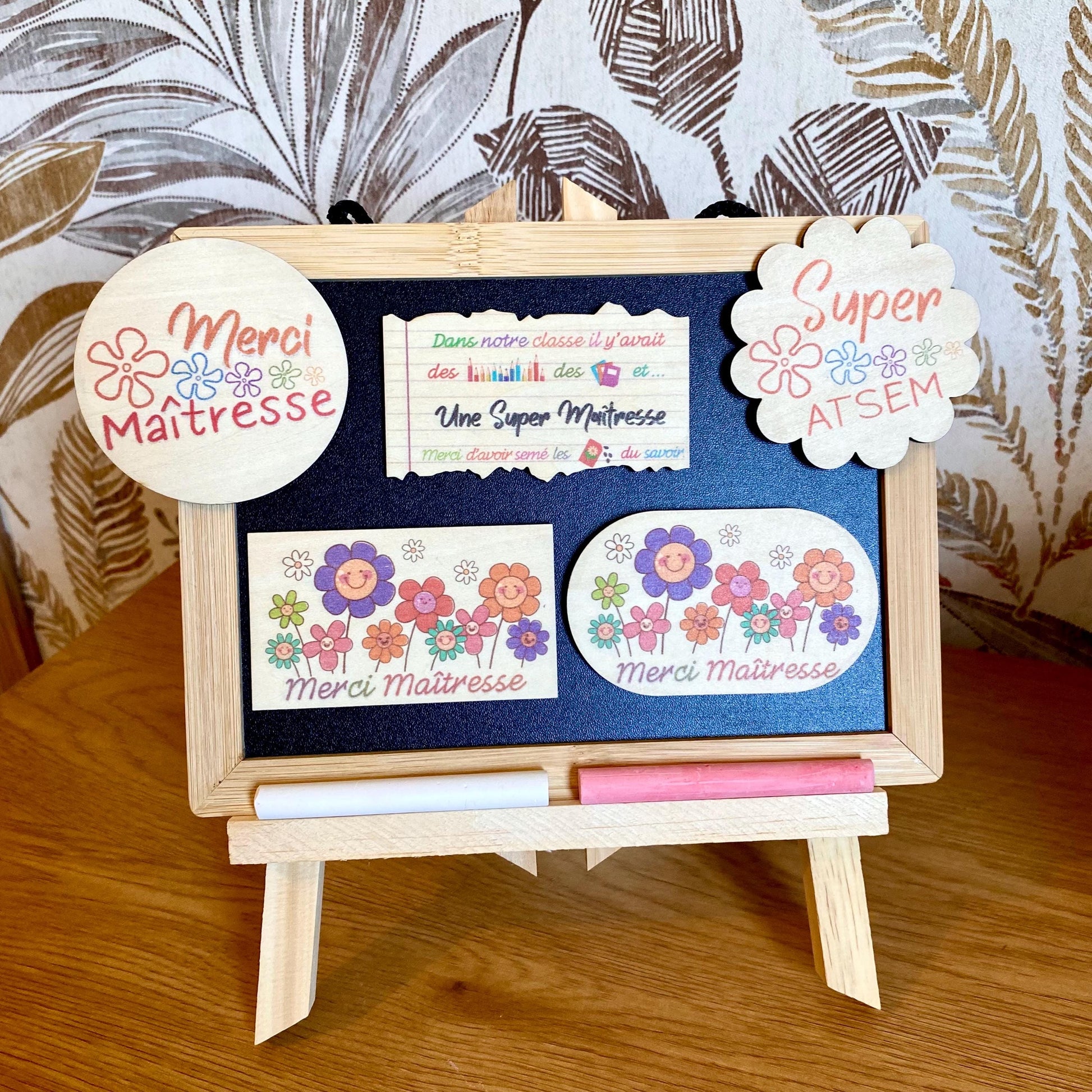 Collection Magnets en bois personnalisés en forme de fleur et de feuille de cahier, disposés à côté de leur emballage cadeau en papier de soie beige."