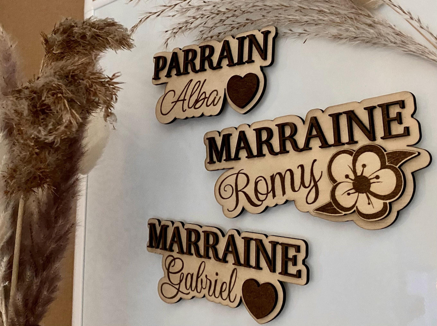Magnet XXL en bois avec le mot 'Marraine'  parrain en relief sur fond floral, posé sur un support décoratif.