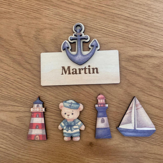 Assortiment de marque-places en bois thème marin (ourson, phare, ancre, bateau).
