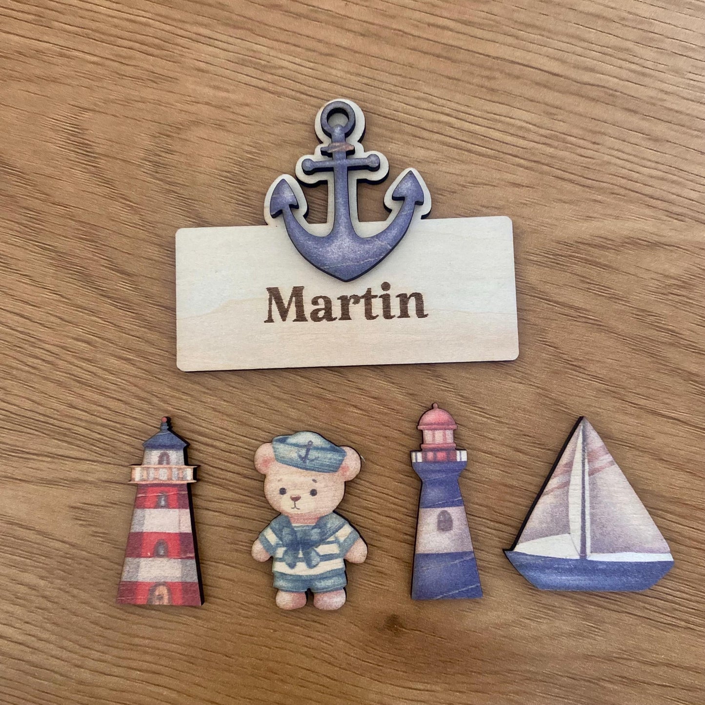 Assortiment de marque-places en bois thème marin (ourson, phare, ancre, bateau).
