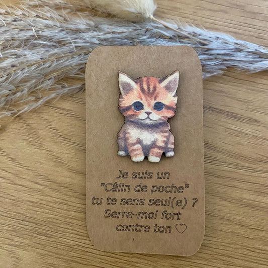 Gros plan sur le Câlin de Poche Chaton en bois, présenté sur un fond doux et chaleureux.