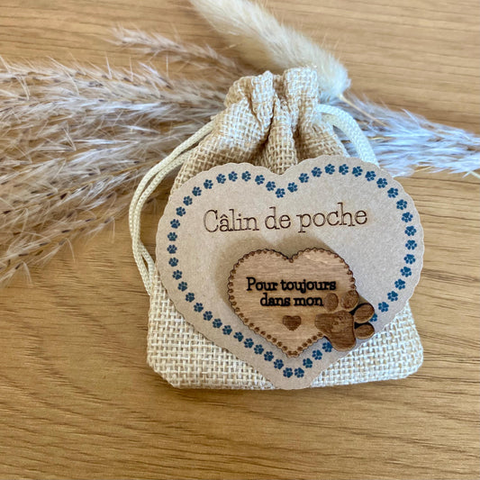 Le Câlin de Poche "Toujours dans mon cœur" posé délicatement sur une surface douce, éclairé par une lumière apaisante.