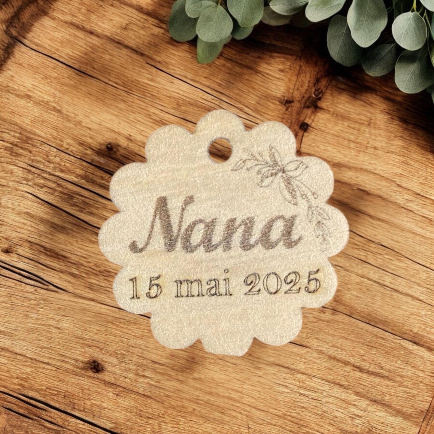 "Une étiquette bois accrochée à un sachet de dragées pour un mariage, illustrant le rendu final sur votre décoration